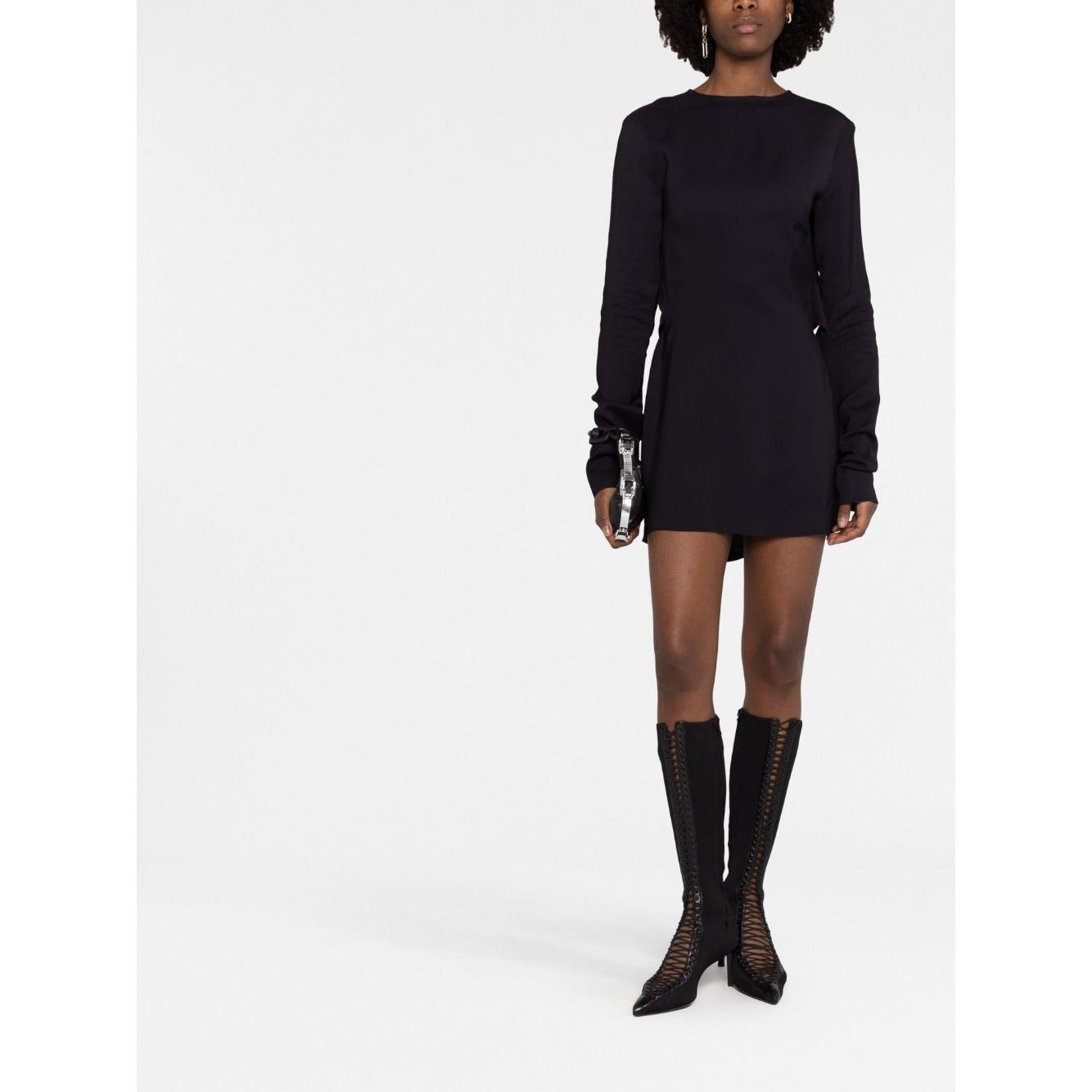Model wearing 032C black short dress with long sleeves, straight hem, and cut-out detailing, styled with knee-high lace-up boots.