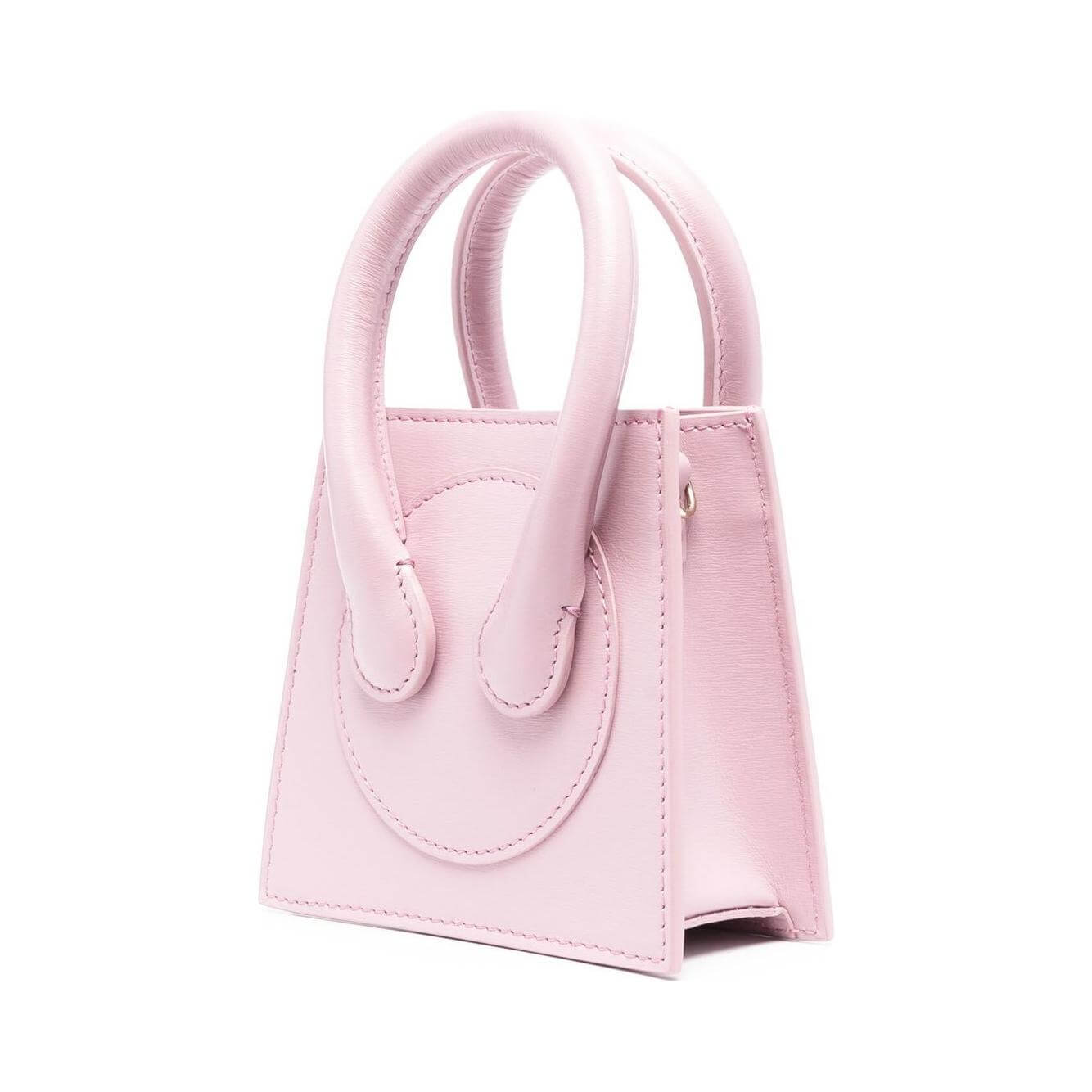 Light pink mini tote bag with logo stamp and rolled handles, featuring adjustable strap and internal card slot.