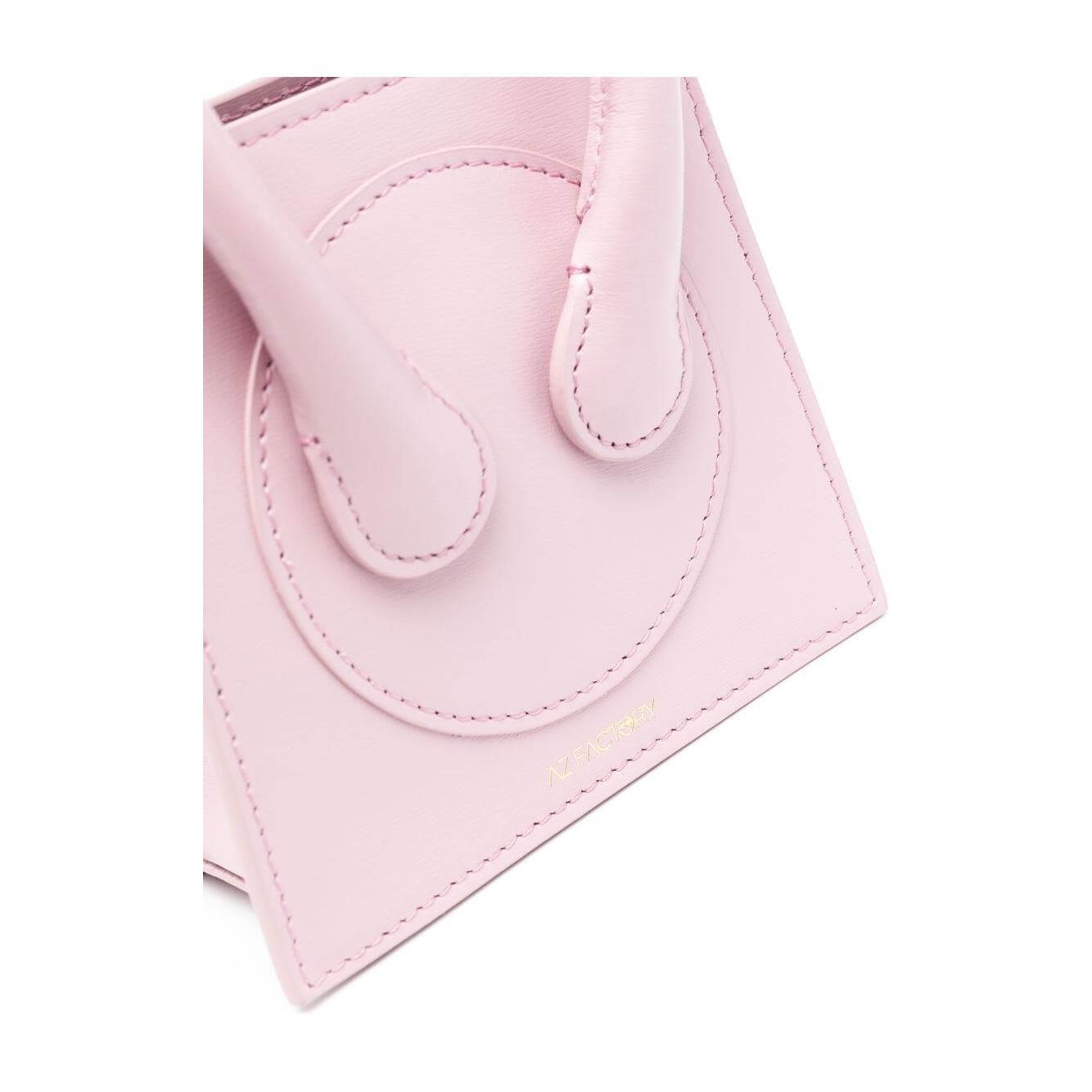 Close-up of light pink Az Factory x Ester Manas Cake mini tote bag with logo stamp and rolled top handles.