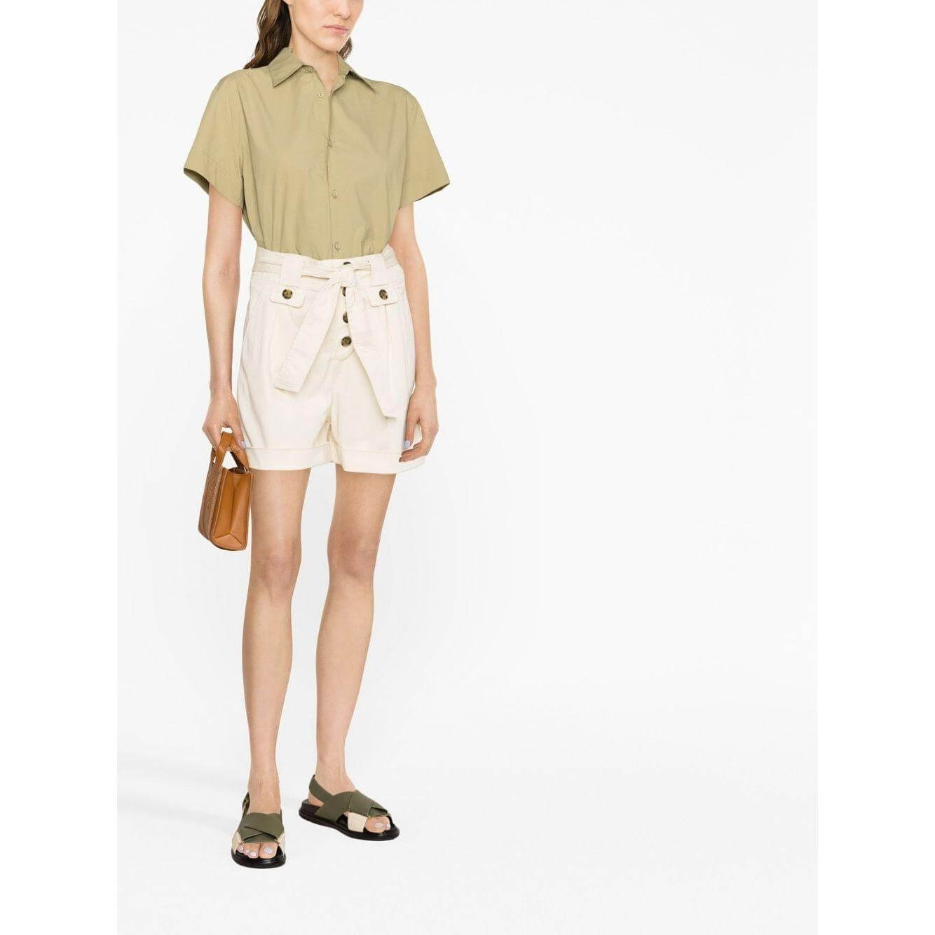 Woman wearing Woolrich tied-waist cotton shorts in beige with turn-up hem, paired with a light green short-sleeve shirt.