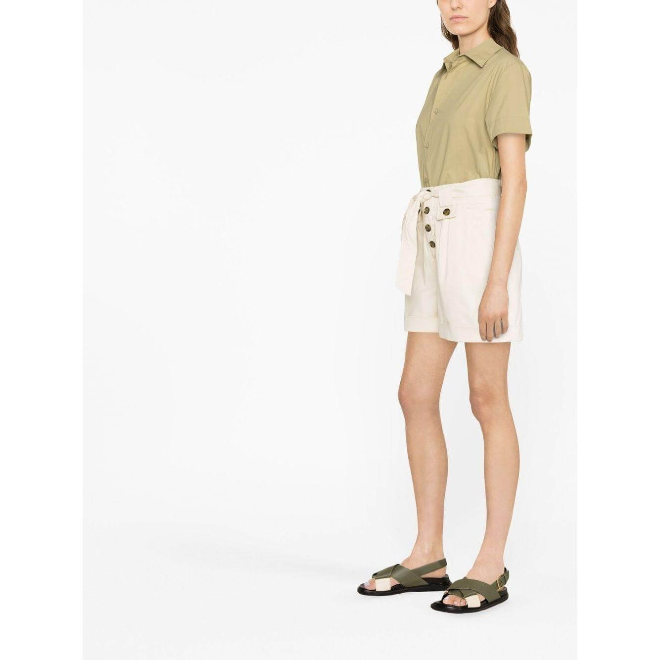 Model wearing Woolrich beige tied-waist cotton shorts with turn-up hem, front button fastening, thigh-length, paired with green shirt and sandals.
