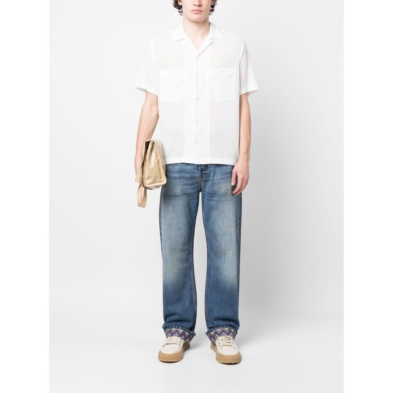Model wearing Missoni stonewashed blue jeans with zigzag hem, straight leg style.
