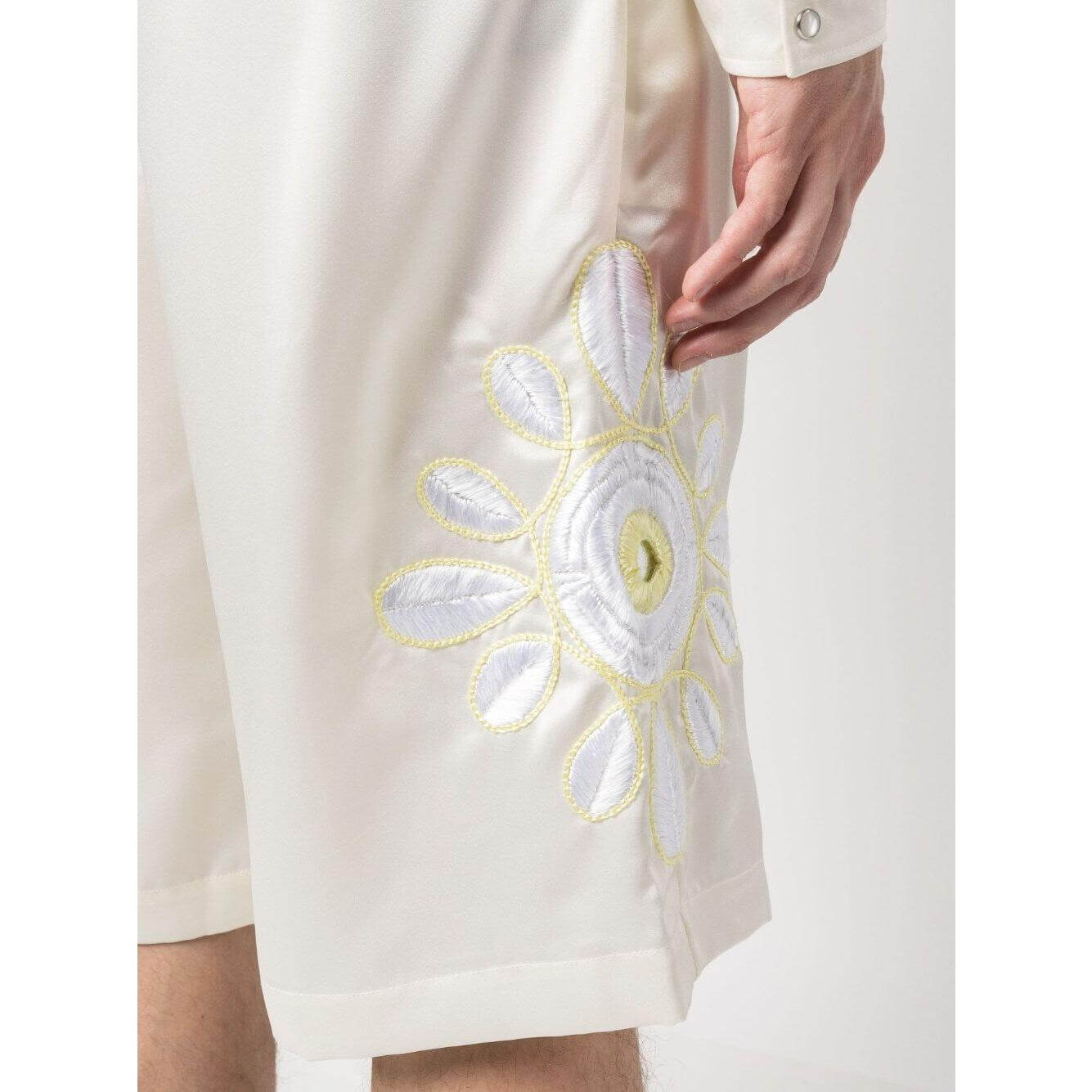 Close-up of cream white embroidered satin shorts with floral motif and side slash pocket from BLUEMARBLE.