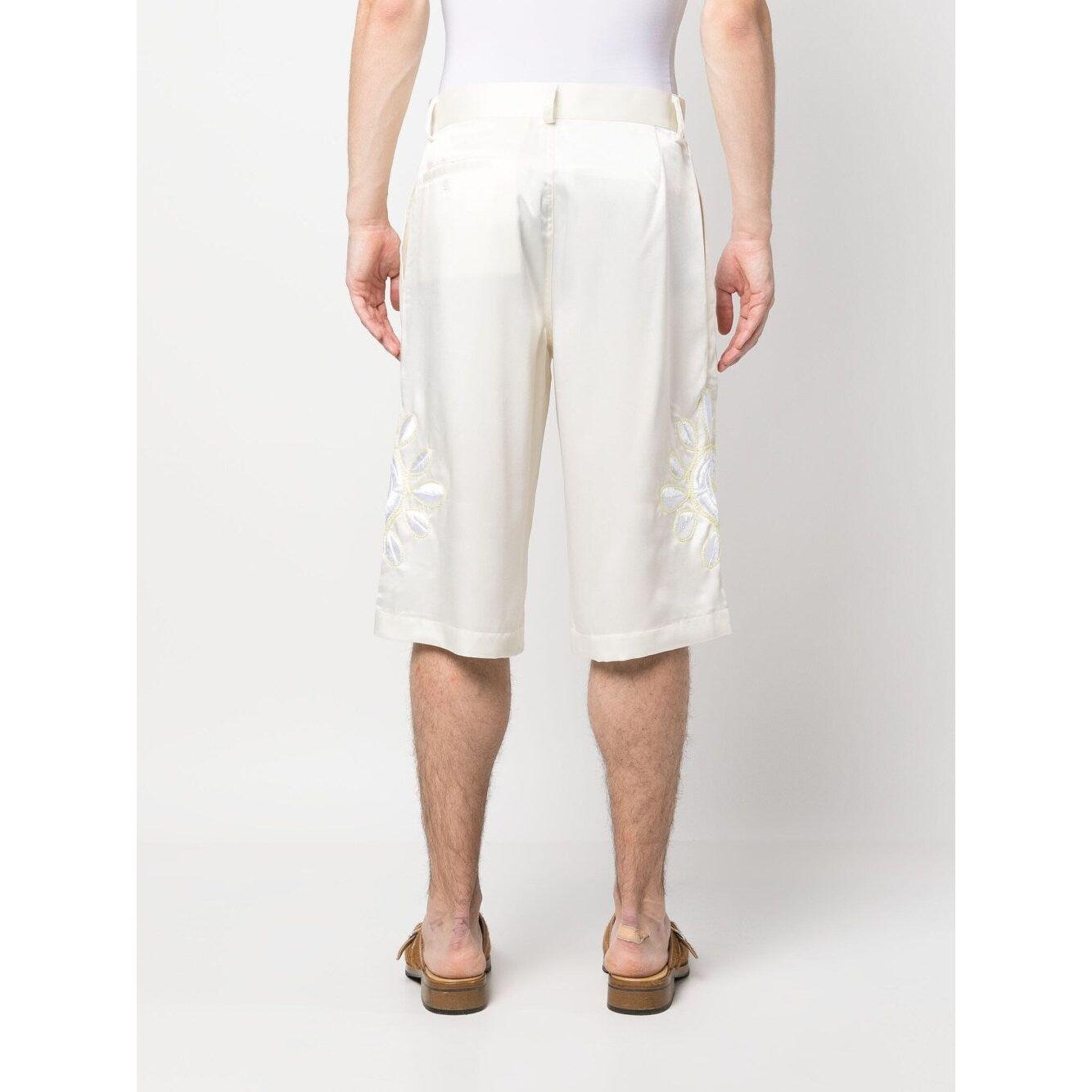 Rear view of cream white BLUEMARBLE embroidered satin shorts, featuring belt loops, knee-length style, worn by a model.