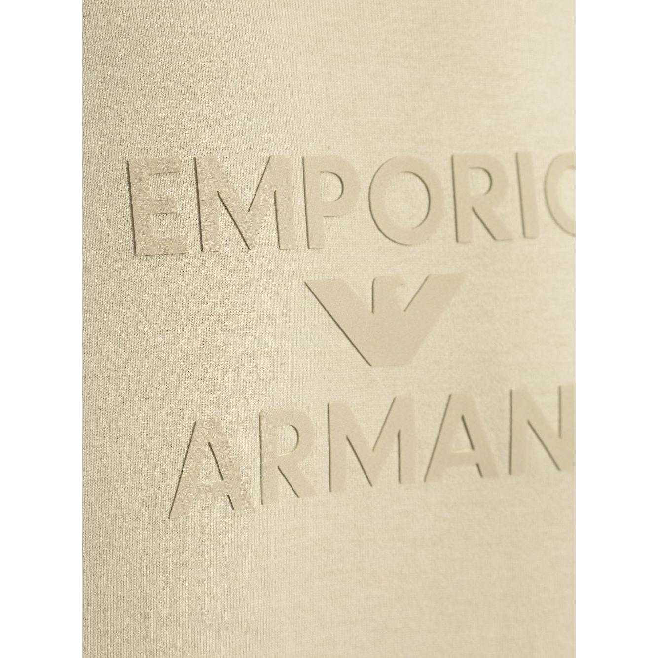 Beige Emporio Armani T-shirt with embossed logo design, showing a close-up of the front cotton fabric.