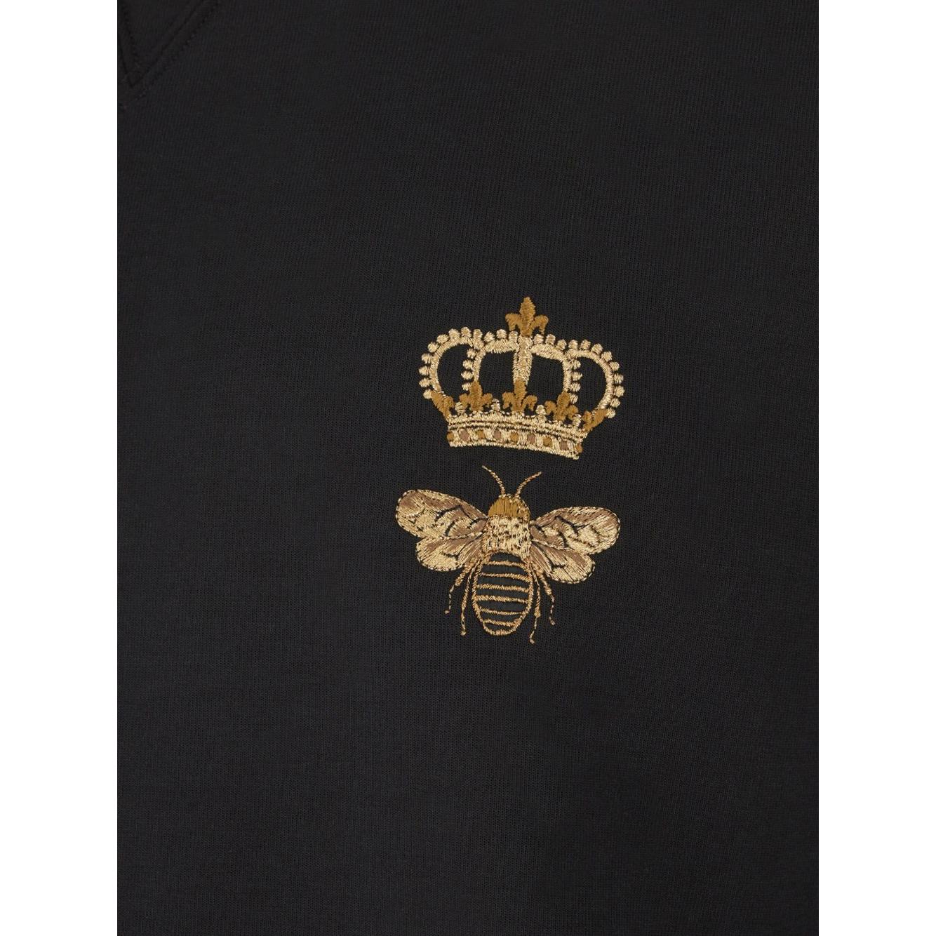 Close-up of Dolce & Gabbana black sweatshirt with bee and crown embroidery.