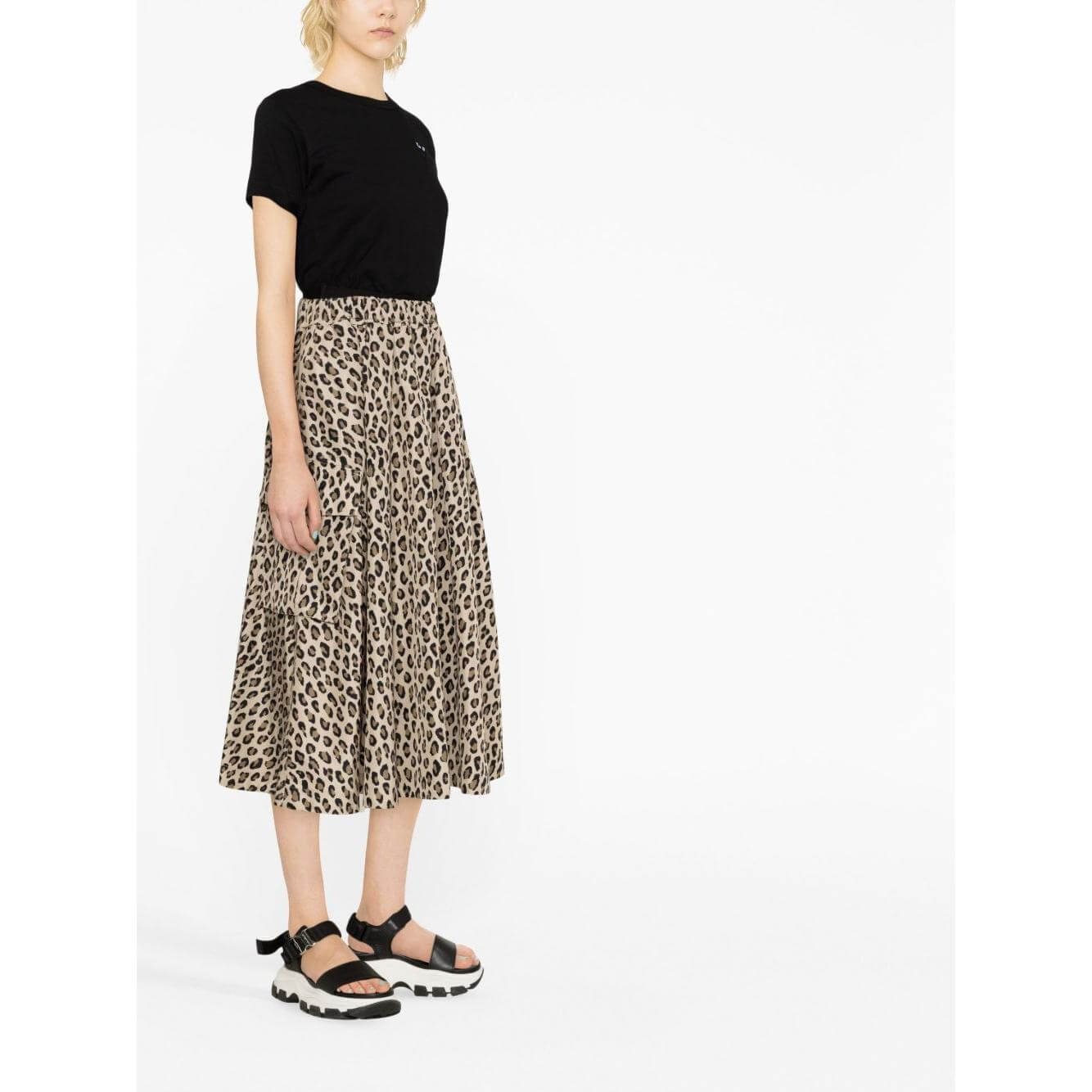 Model wearing black Comme des Garcons T-shirt with leopard print skirt and sandals.