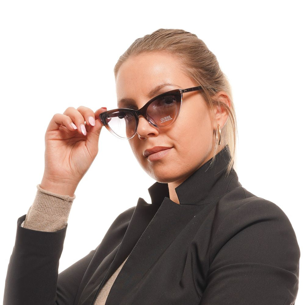 Woman wearing Guess brown cat eye sunglasses with purple gradient lenses and full-rim plastic frame. Fashionable eyewear for women.