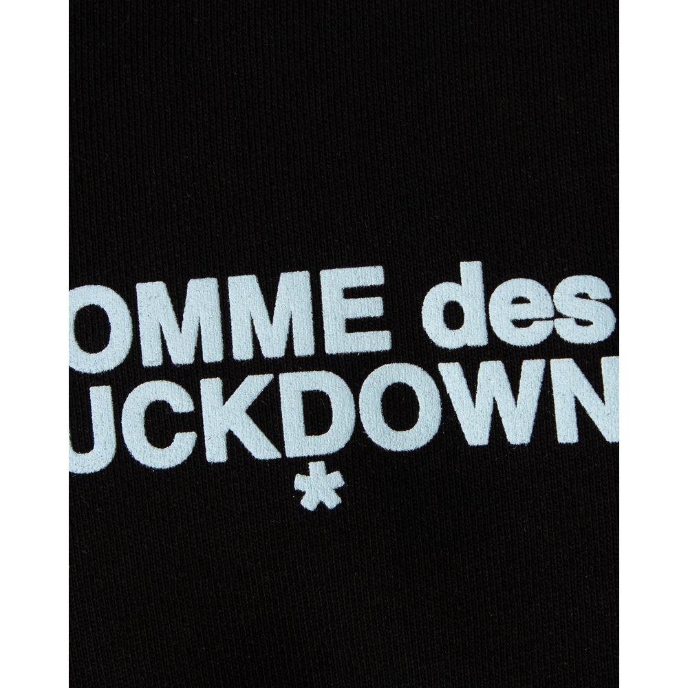 Close-up of Comme Des Fuckdown logo printed on a black cotton sweater.