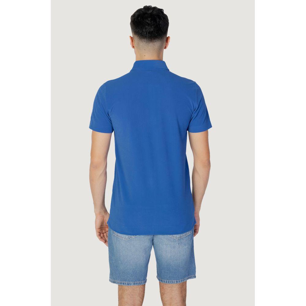 Back view of men's short sleeve blue polyester polo shirt, spring/summer collection, model wearing denim shorts.