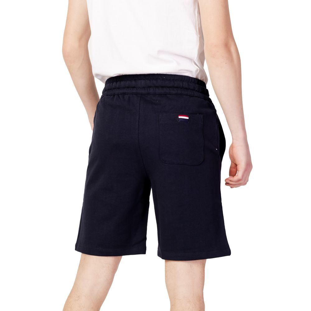 Back view of a man wearing U.S. POLO ASSN. blue cotton Bermuda shorts, part of the men's spring/summer collection, made of 100% cotton.