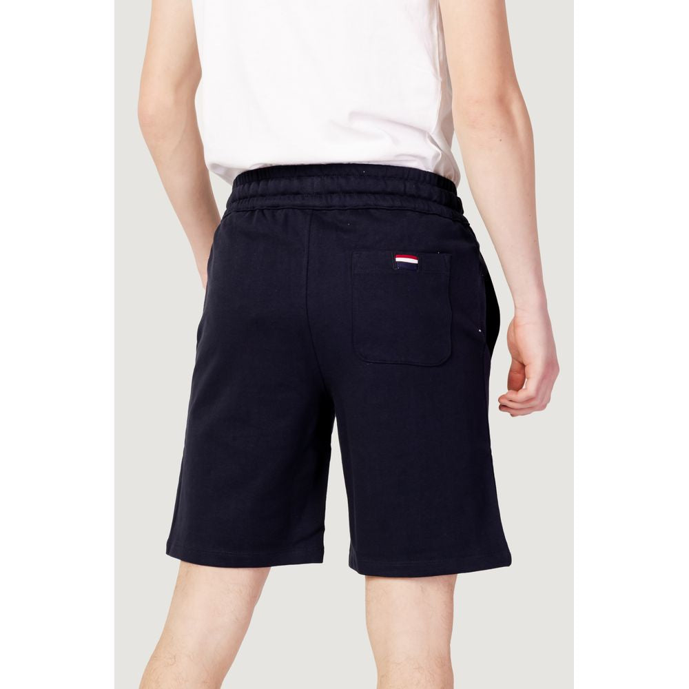 Man wearing U.S. POLO ASSN. blue cotton Bermuda shorts; perfect for men's spring/summer fashion, 100% cotton.