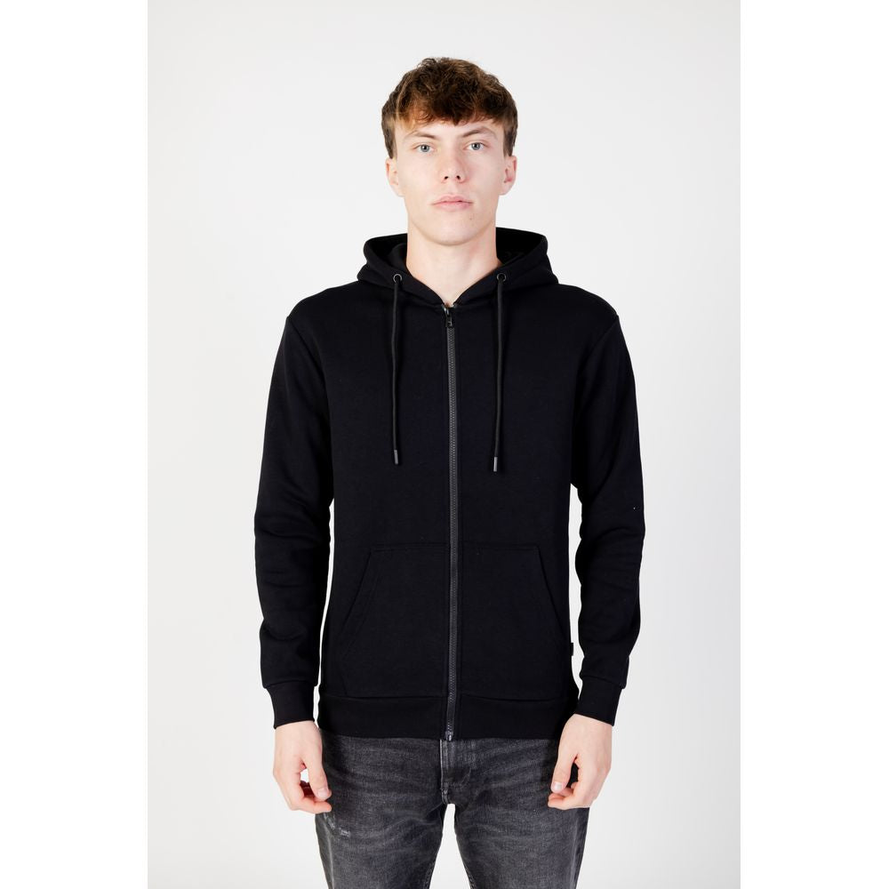 Young man wearing Jack Jones Black Polyester Hoodie with full zip and drawstring hood, showcasing trendy design and comfort.