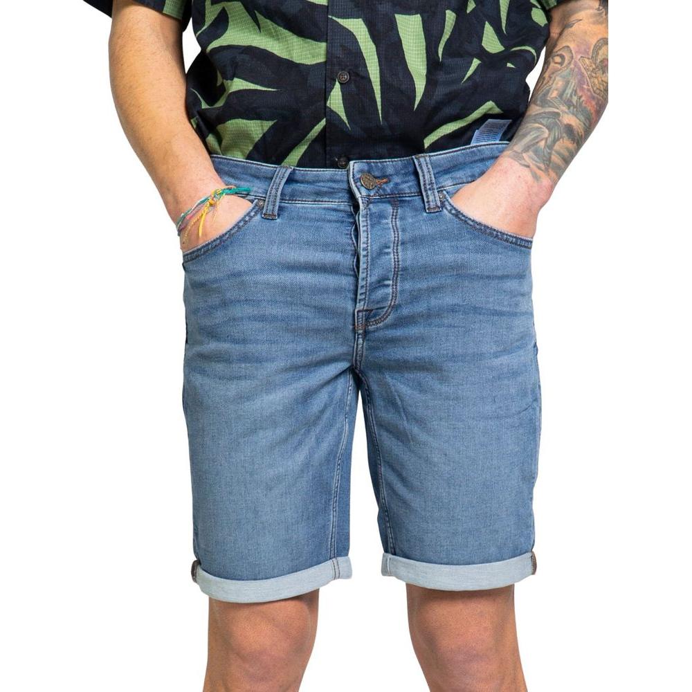 Model wearing Only & Sons blue cotton shorts with rolled cuffs, paired with a casual black and green shirt.