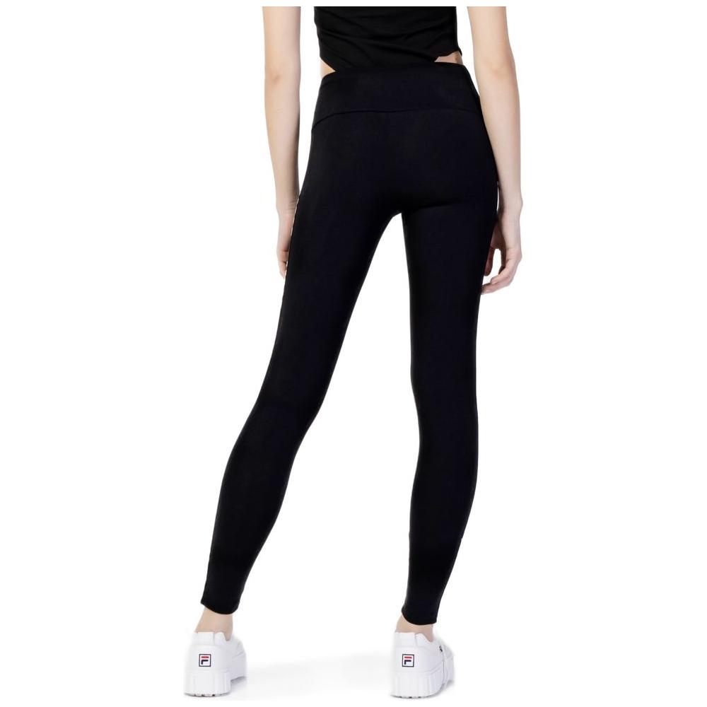 Woman wearing Guess Active black cotton leggings with high waist design, featuring logo on side, perfect for sports and active wear.