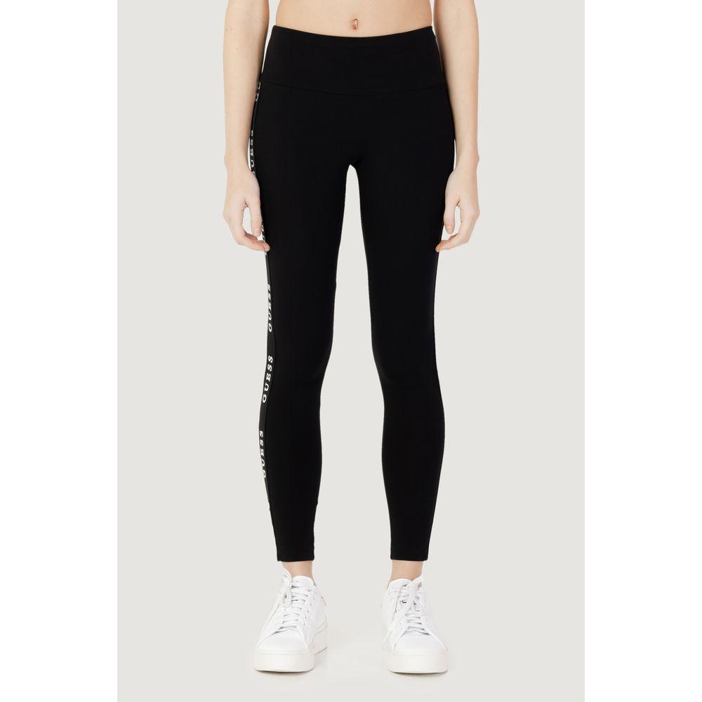 Woman wearing Guess Active black cotton leggings with logo, featuring high waist and fitted design for comfort and support.