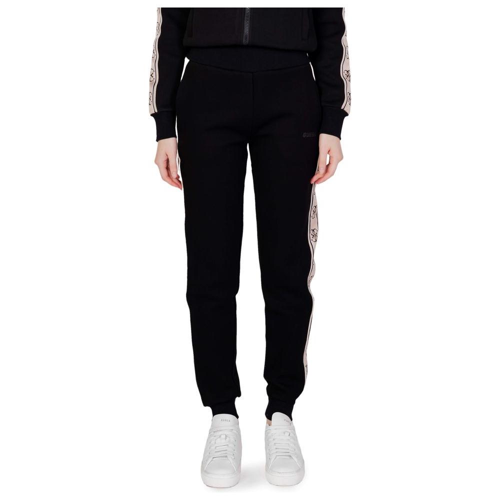 Model wearing Guess Active Britney Jogger sweatpants in black cotton, showcasing modern design and comfort with elastic waistband.