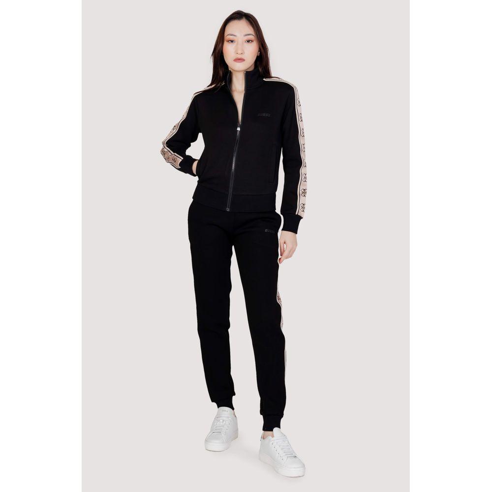 Model wearing Guess Active black cotton jogger set with zipper and side stripe design, perfect for style and comfort.