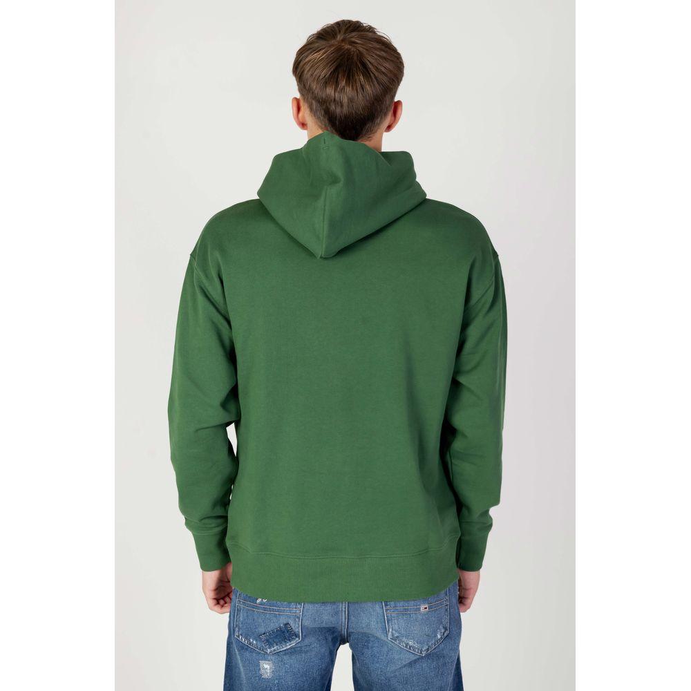 Back view of a green cotton Tommy Hilfiger hoodie, part of the Autumn/Winter collection. Transitional and Better Cotton Initiative.