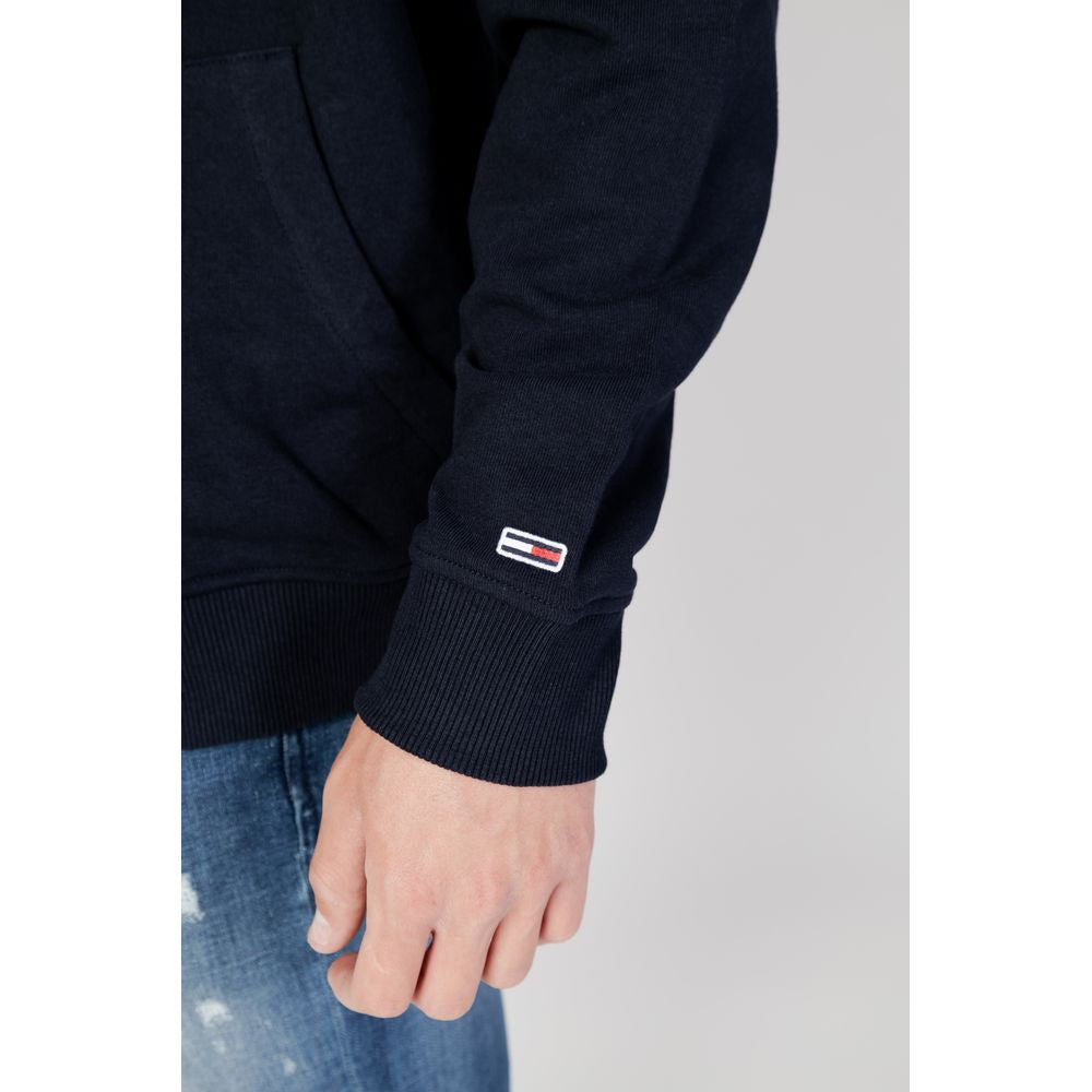 Close-up of a blue organic cotton sweater by Tommy Hilfiger, featuring a men's hoodie style from the fall/winter collection.