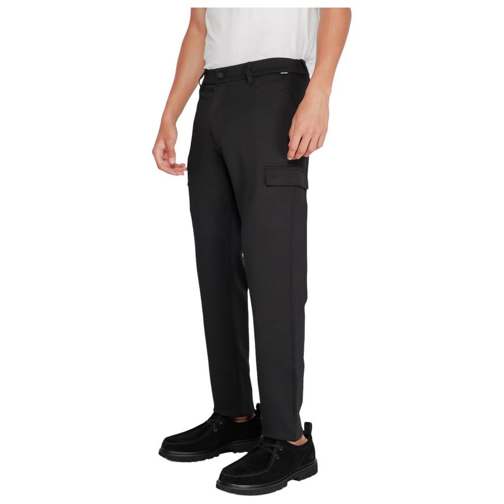 Man wearing Calvin Klein black recycled polyester tapered pants, showcasing sustainable fashion with comfort knit design.
