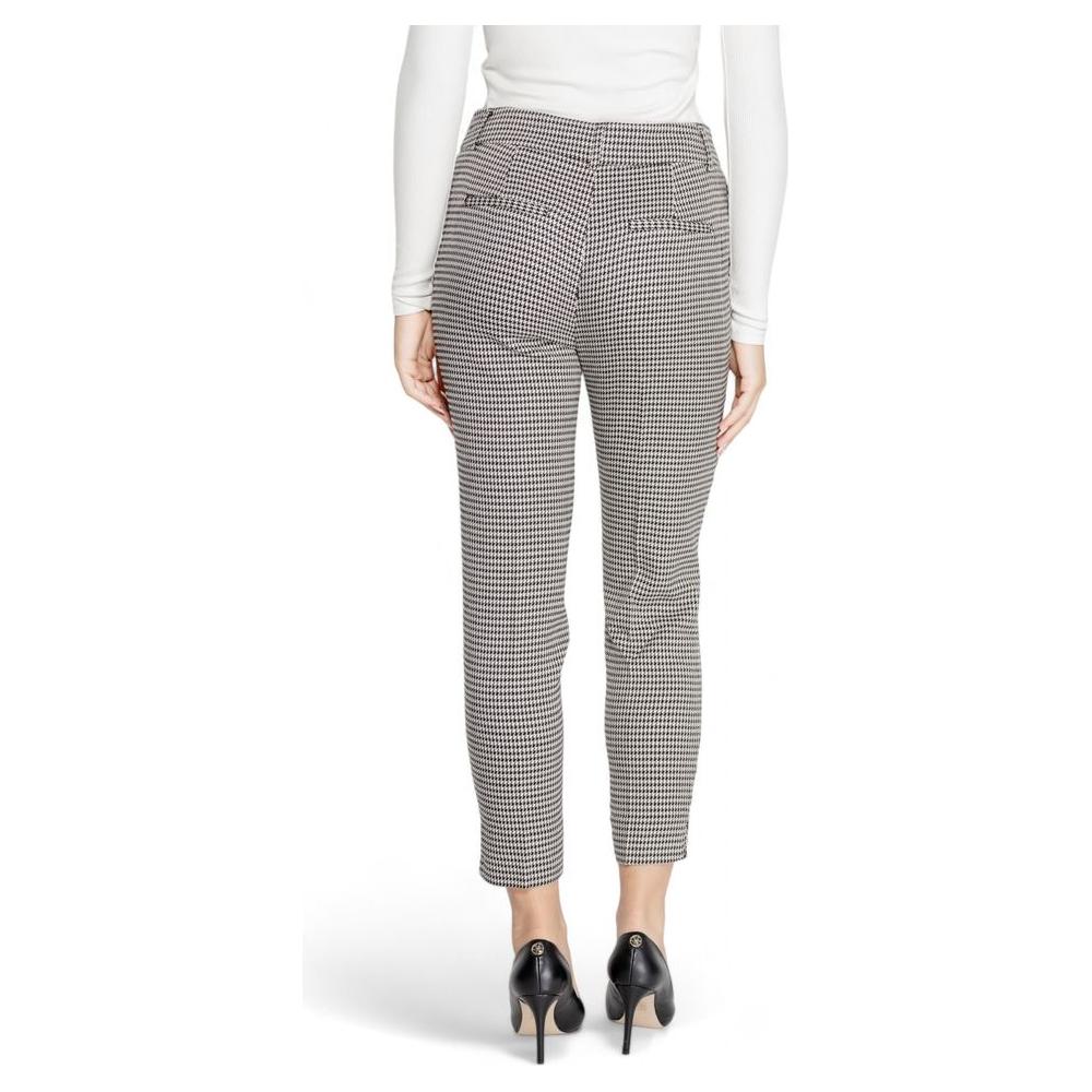 Woman wearing black and white checkered polyester pants, rear view showcasing fall winter style with high heels.