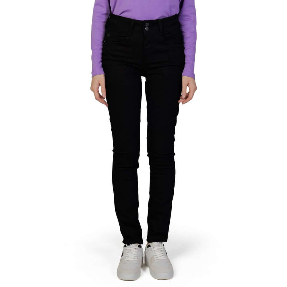 Woman wearing Street One black slim jeans for fall, made of 82% cotton, 15% polyester, and 3% elastane, with white sneakers.