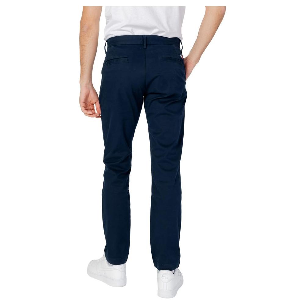 Man wearing Tommy Hilfiger blue organic cotton tapered pants, spring/summer collection. Back view showing full-length jeans.