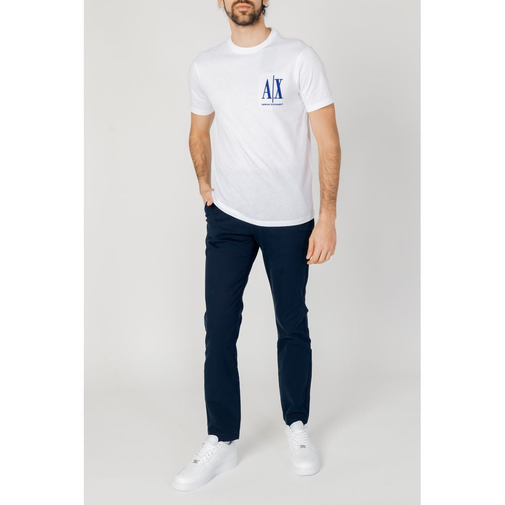 Man wearing white t-shirt and blue tapered pants from Tommy Hilfiger Spring/Summer Collection, crafted with organic cotton and elastane.