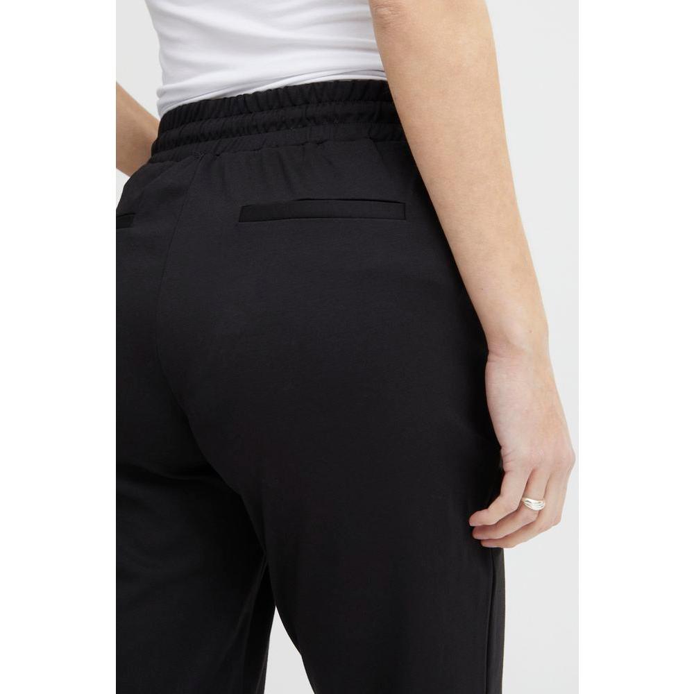 Back view of ICHI black polyester cigarette pants for women, featuring an elastic waistband. Ideal for Fall/Winter collection.