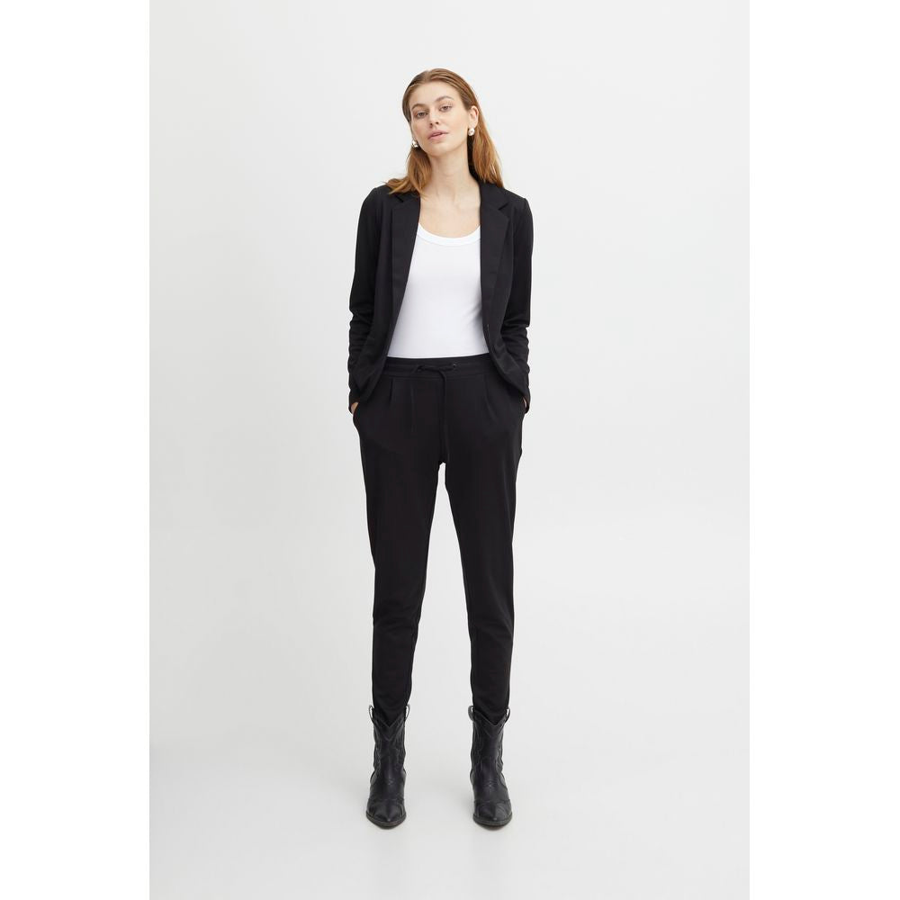 Woman wearing ICHI black polyester women's cigarette pants, fall/winter collection, showcasing stylish and comfortable design.