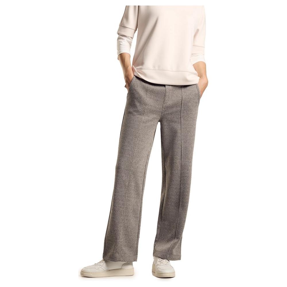 Woman wearing loose fit gray pants with pockets and white sneakers, showcasing fall winter fashion, comfortable and stylish