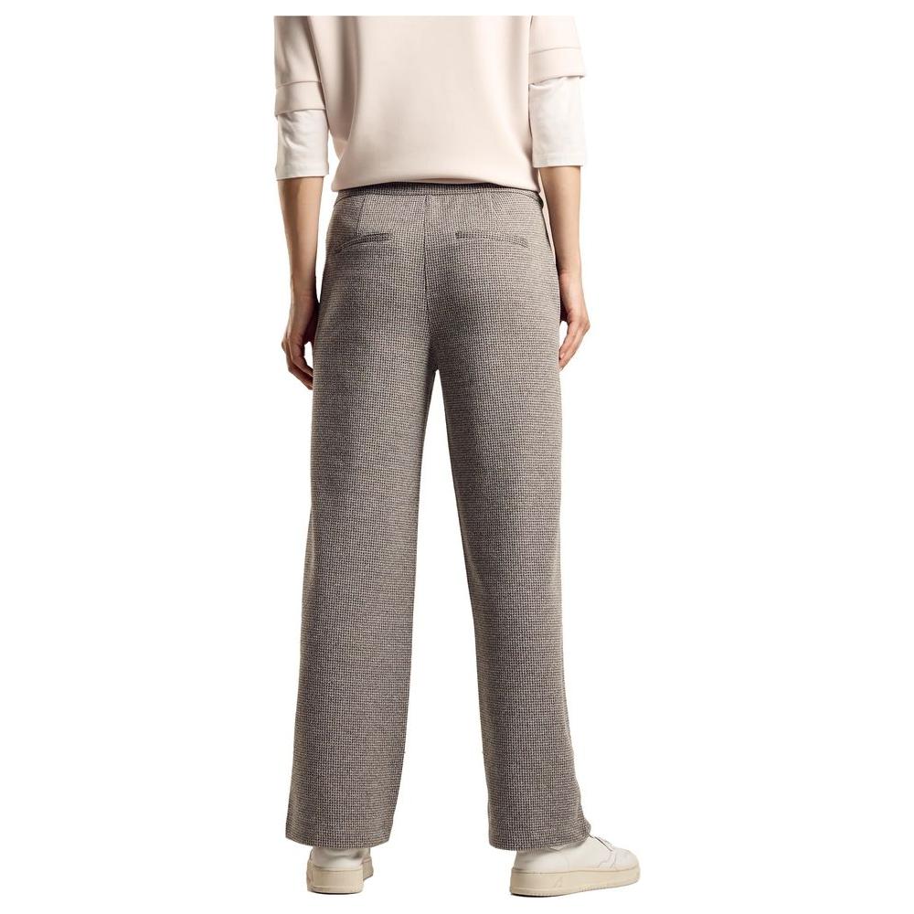Woman wearing beige wide-leg pants, back view, highlighting comfort and style for the fall/winter season.