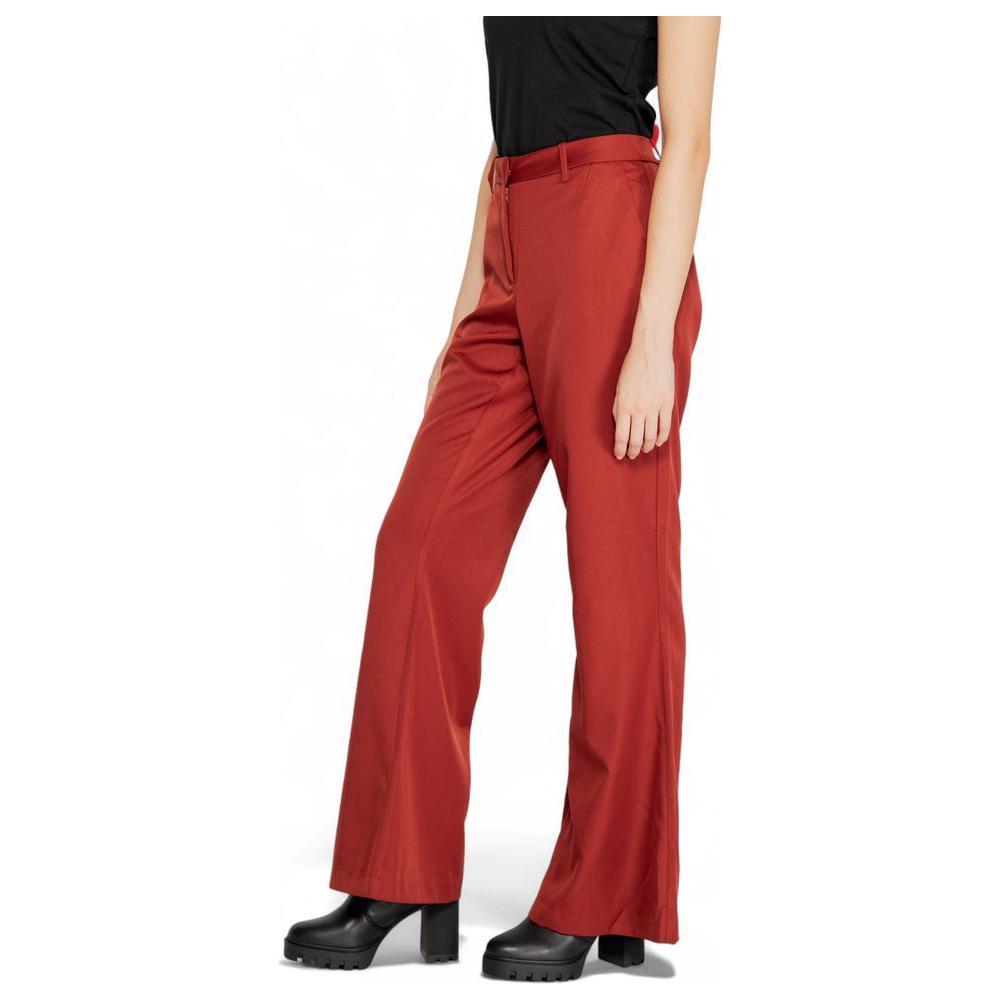 Woman wearing Vero Moda red polyester pants, fall/winter collection. Stylish and comfortable women's fashion.