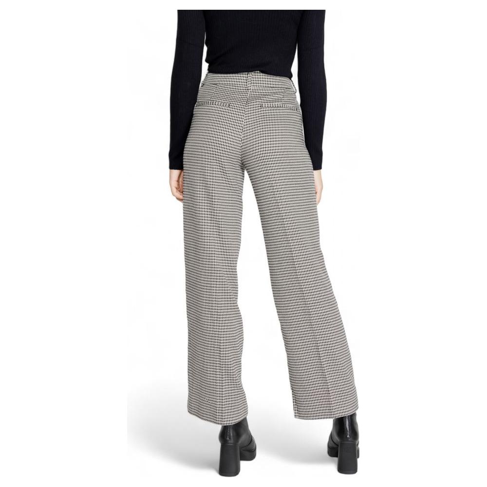 Woman wearing high-waisted houndstooth wide-leg pants with black top and boots, showcasing back view for fall/winter collection.