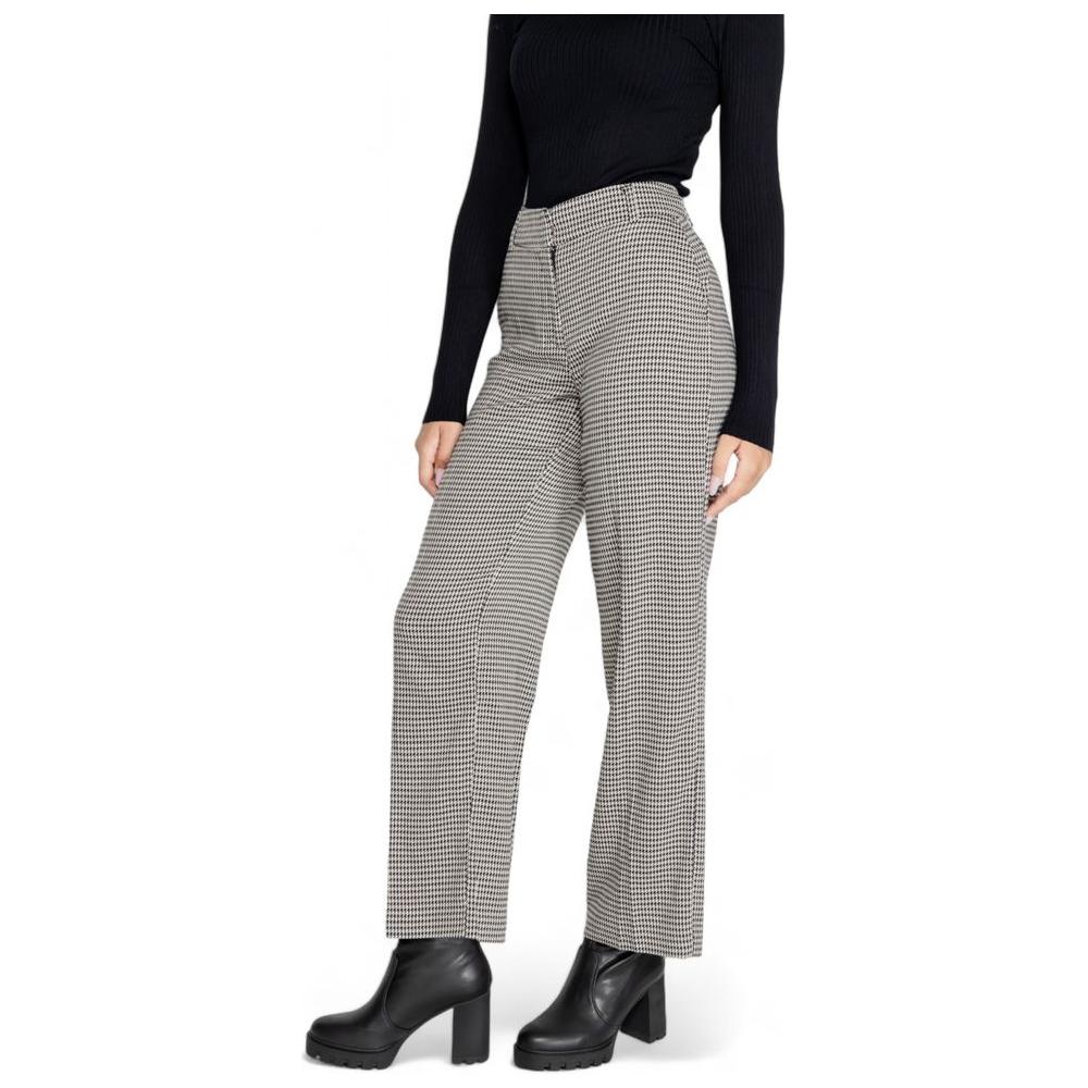 Woman modeling fall/winter houndstooth polyester pants with high waist and flare leg, styled with black top and boots.