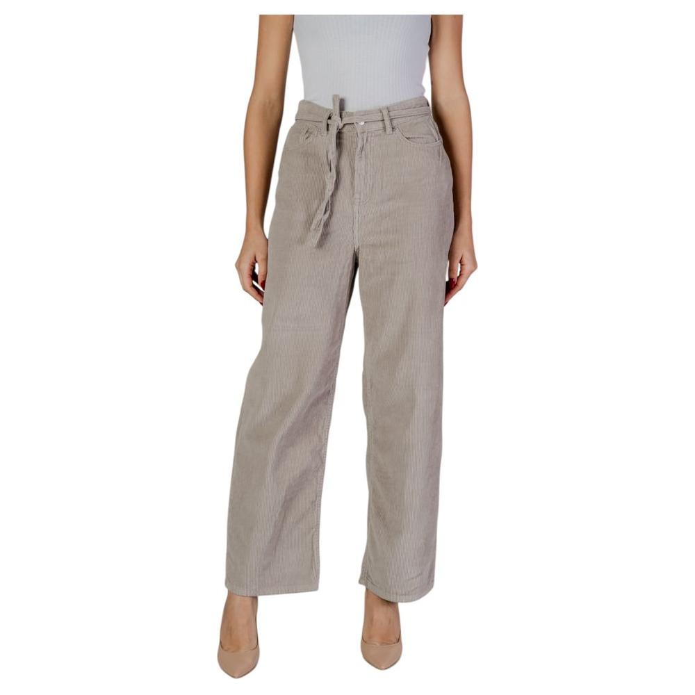 Woman wearing beige cotton baggy pants, fall/winter collection, 100% cotton, for casual style and comfort.
