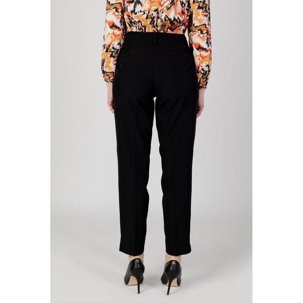 Back view of women's black cigarette pants made from recycled polyester, part of autumn/winter collection.