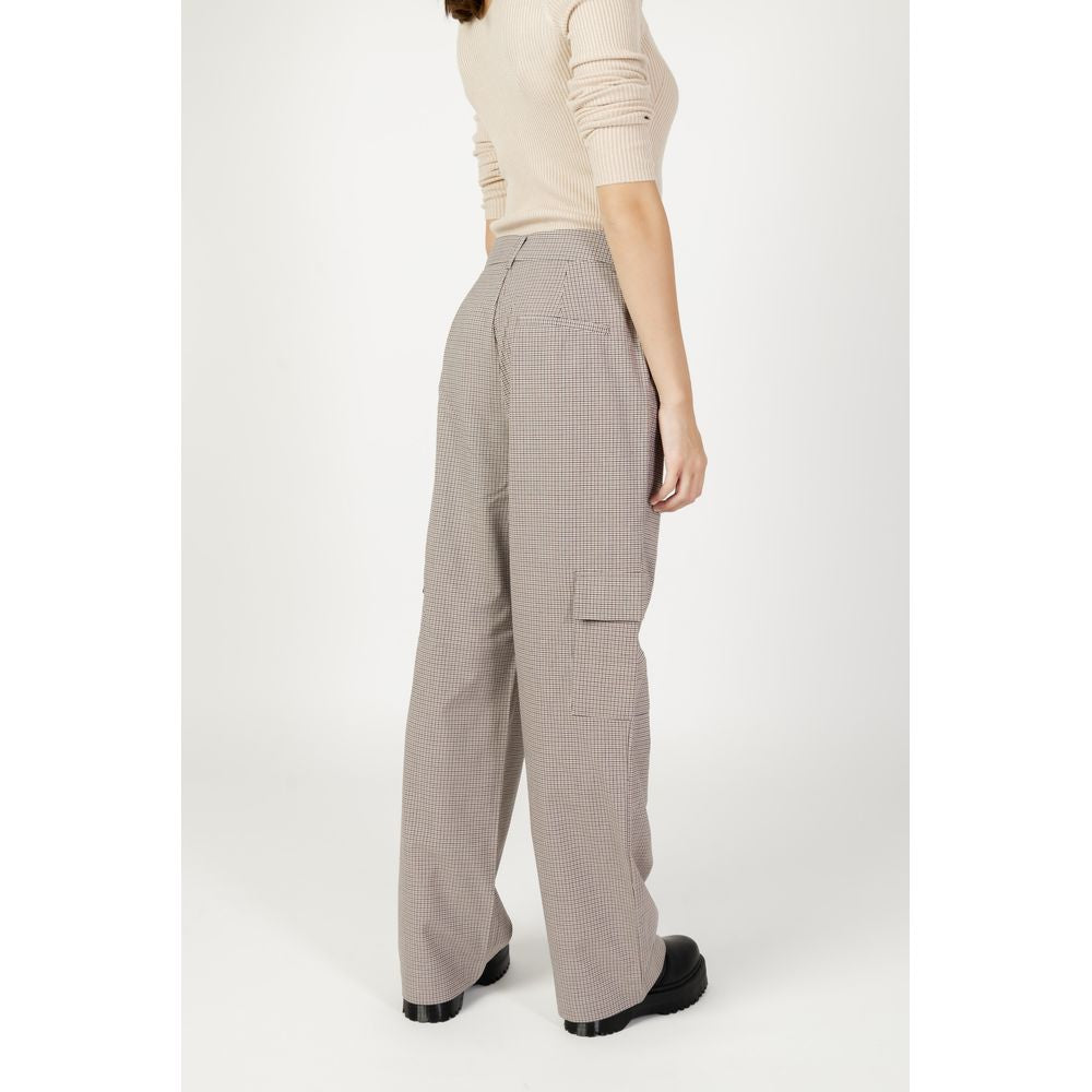 Back view of woman wearing beige women's cigarette pants, autumn/winter collection, made of polyester, viscose, and elastane.