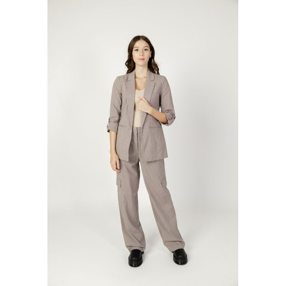 Woman wearing a beige blazer and pants set, autumn/winter collection, made of polyester blend with viscosa and elastane.