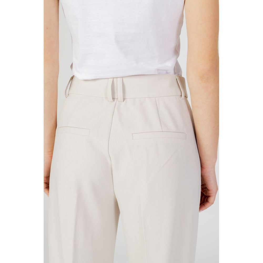 Back view of women's beige cigarette pants made of 98% polyester and 2% elastane, part of the spring/summer collection.