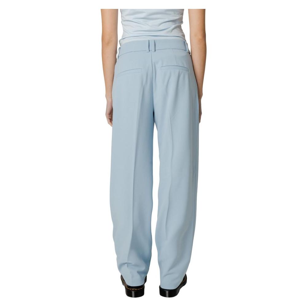 Women's blue polyester cigarette pants from spring/summer collection, shown from the back, featuring 98% polyester and 2% elastane fabric.