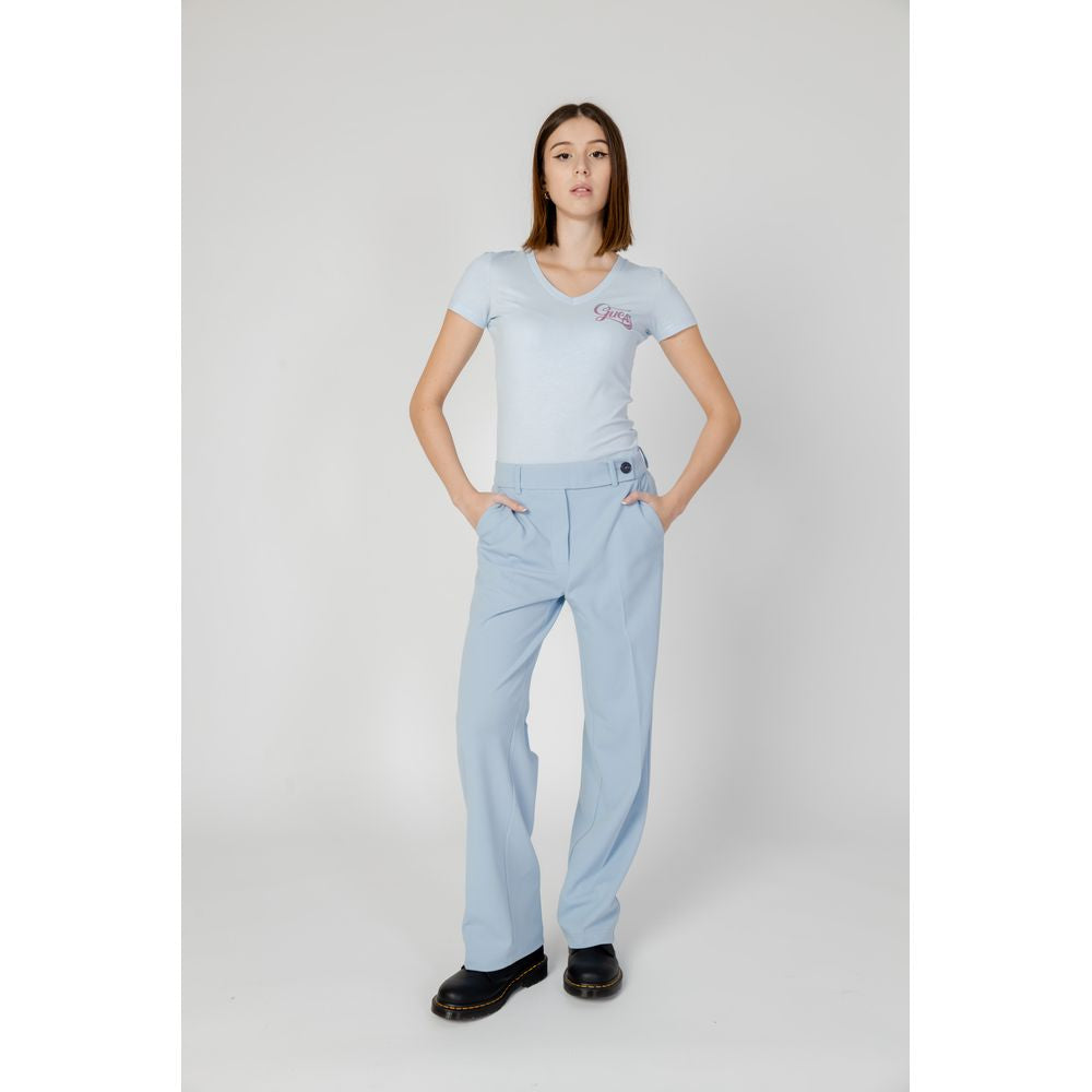 Woman wearing light blue polyester cigarette pants from the Spring/Summer collection, featuring a modern design and comfortable fit.