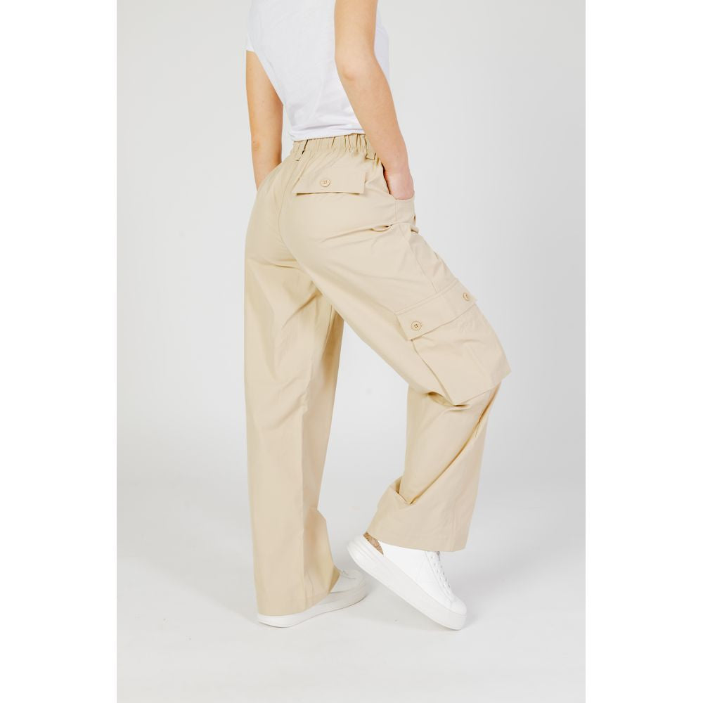 Women's beige cotton pants, spring/summer collection, shown from the side, featuring a relaxed fit and elastic waistband.