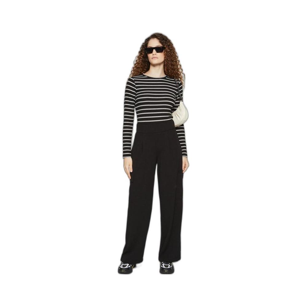Woman wearing Jacqueline De Yong black polyester pants, perfect for spring/summer collection, standing in a stylish outfit.