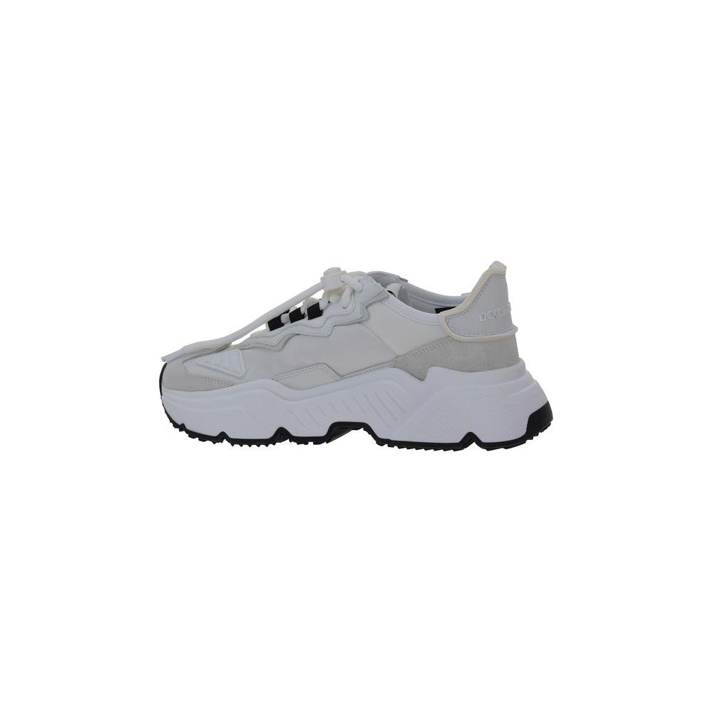 Side view of white Dolce & Gabbana sneakers with oversized rubber sole and contrasting logos on tab and side.