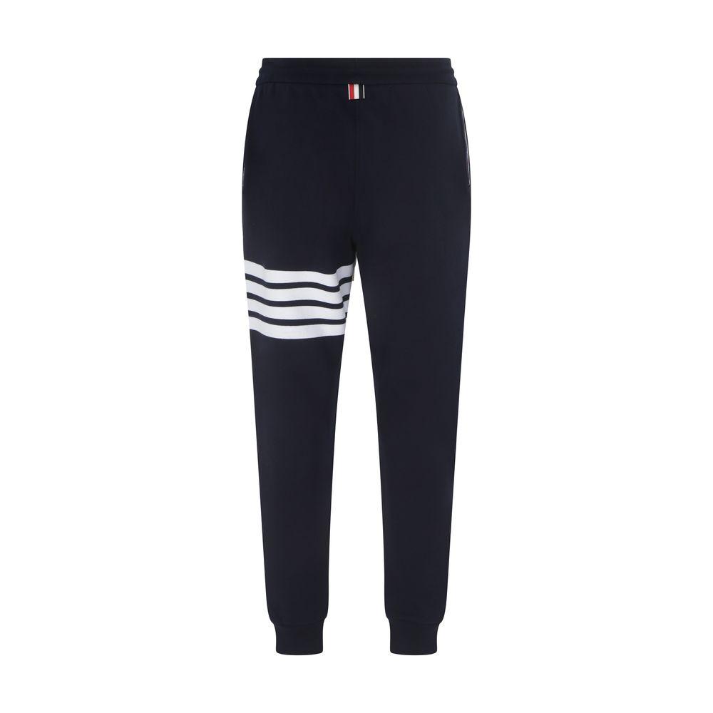 Thom Browne cotton sweatpants, elastic waistband, adjustable drawstring, white bands on left leg, back brand patch, jogger style.