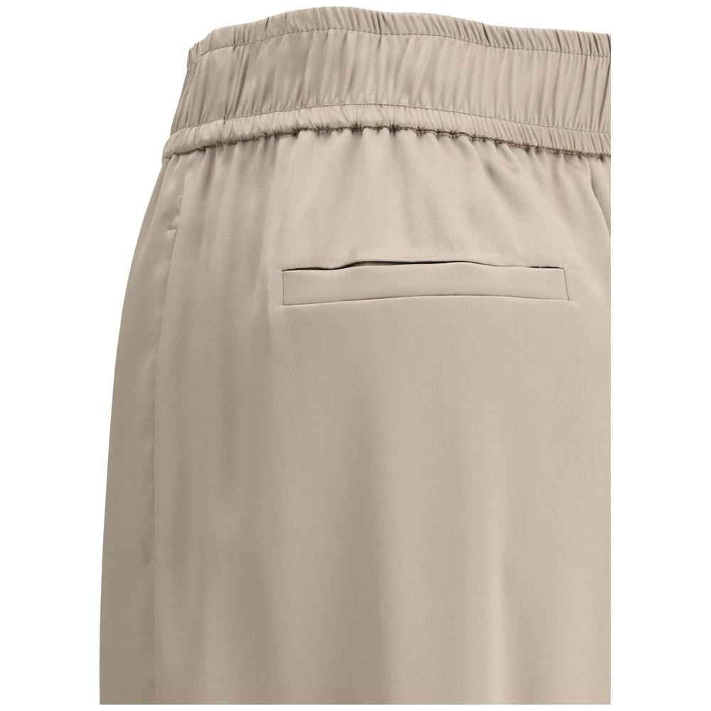 Close-up of Brunello Cucinelli silk palazzo pants showing elasticized waistband and back welt pocket, beige color.