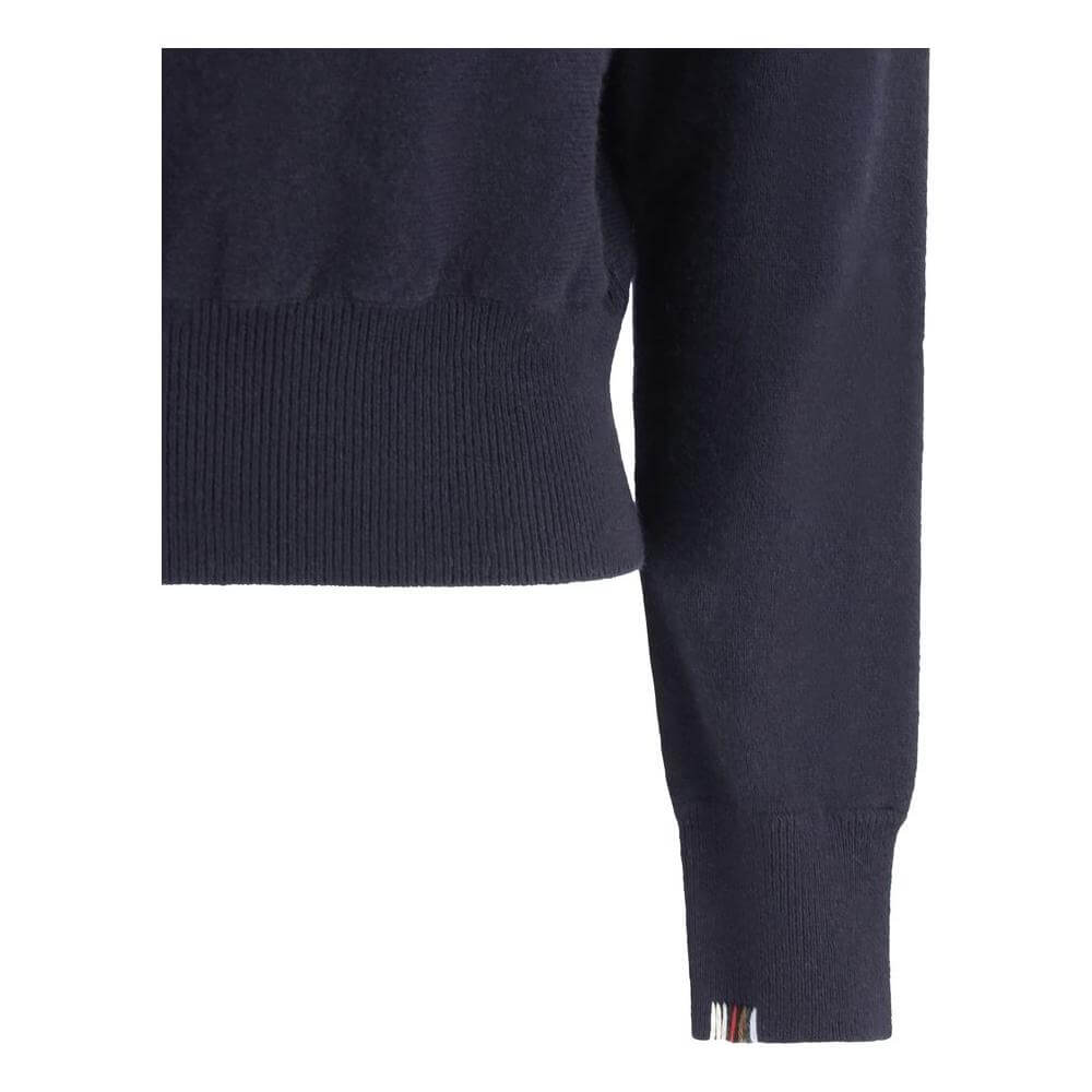 Close-up of black Extreme Cashmere Belle Sweater showing ribbed cuffs and hem, highlighting its elegant and versatile design.