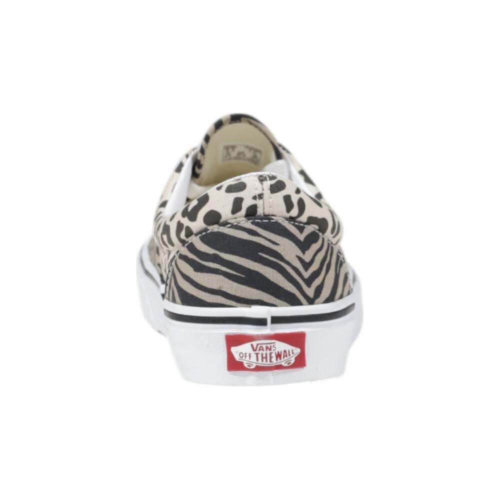 Rear view of Vans beige fabric sneaker with zebra and leopard print design, showing red logo on white rubber sole.